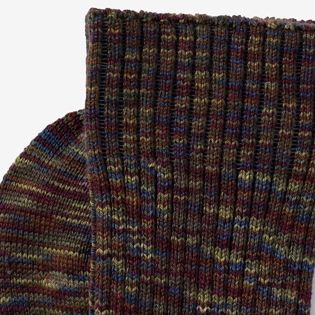 Close-up of multicolored socks in deep burgundy, olive green, muted blue, brown, and subtle gold tones. 