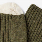 Close-up of green and cream colored wool socks.