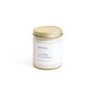 Candle jar labeled 'Santal' with a gold lid on a white background