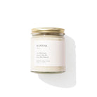 Santal candle with a white label and gold lid on a white background