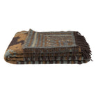 Folded patterned blanket with fringes on a white background