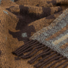 Close-up of a brown and gray patterned blanket with fringes
