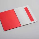 Open exercise lined notebook with red cover on light background