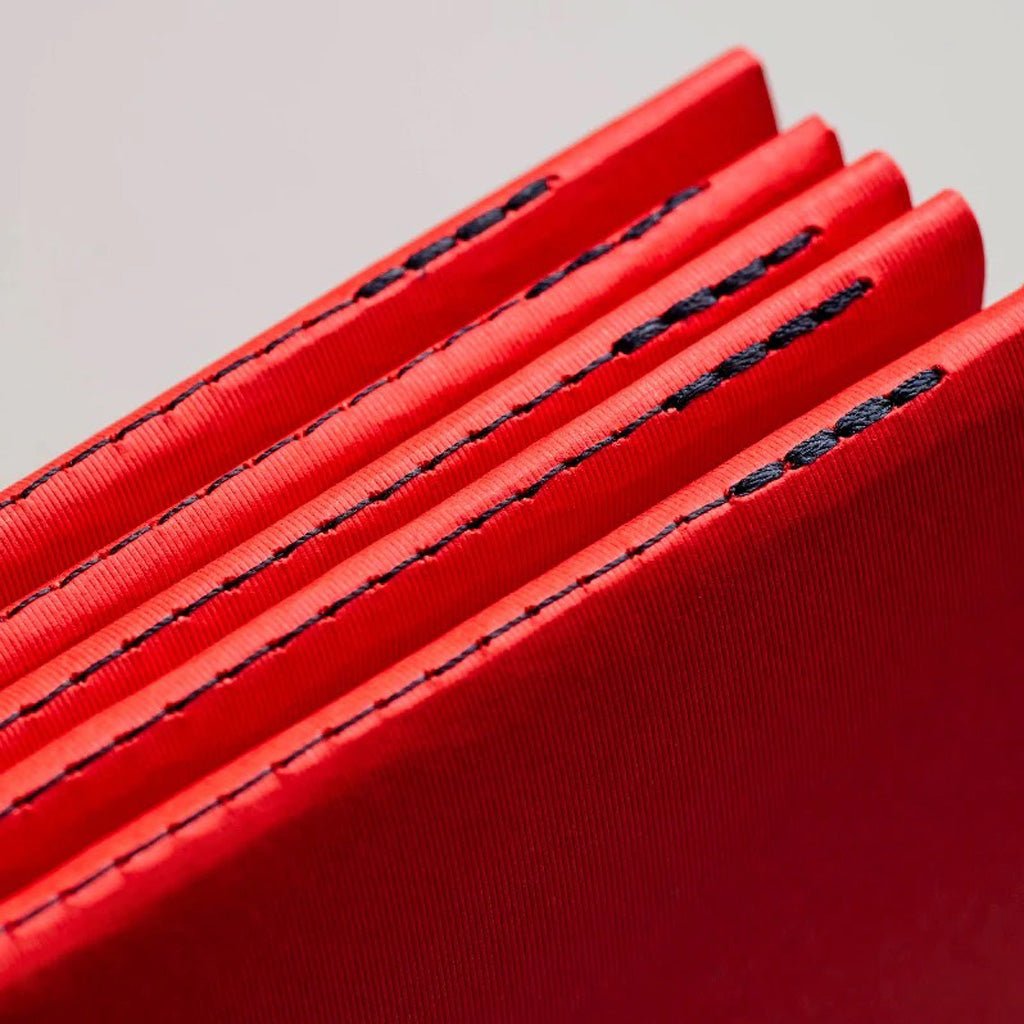 Close up of stitching on red notebooks