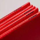 Close up of stitching on red notebooks