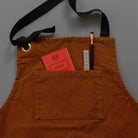 Mini pocket red notebook tucked into apron pocket next to ruler and pencil