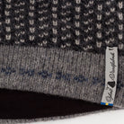 Close-up of a textured fabric with a brand tag on a black background