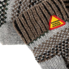 Knitted mittens with a triangular warning label on a patterned background