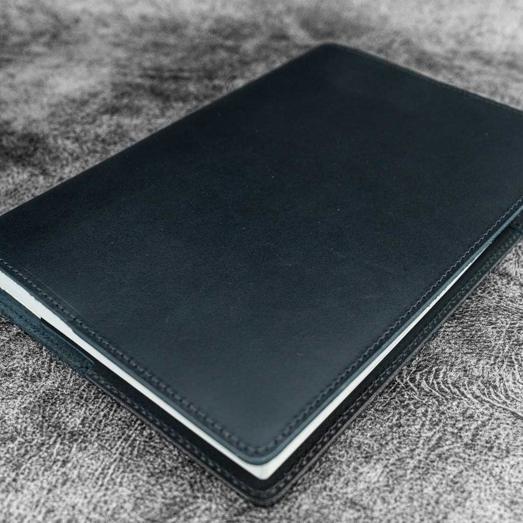 Black leather notebook on a textured surface