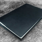 Black leather notebook on a textured surface