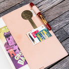 Open notebook with natural undyed leather notebook cover with a pen on a wooden surface