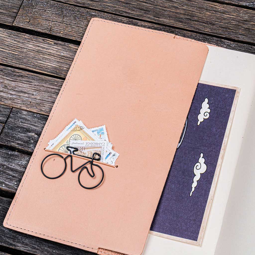 Open notebook with natural undyed leather notebook cover on a wooden surface