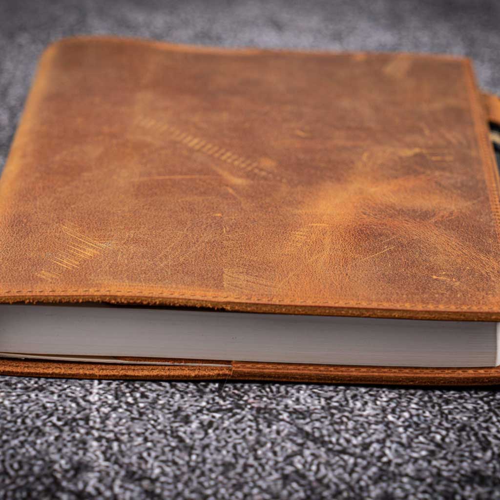 Brown leather notebook on a textured gray surface