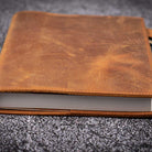 Brown leather notebook on a textured gray surface