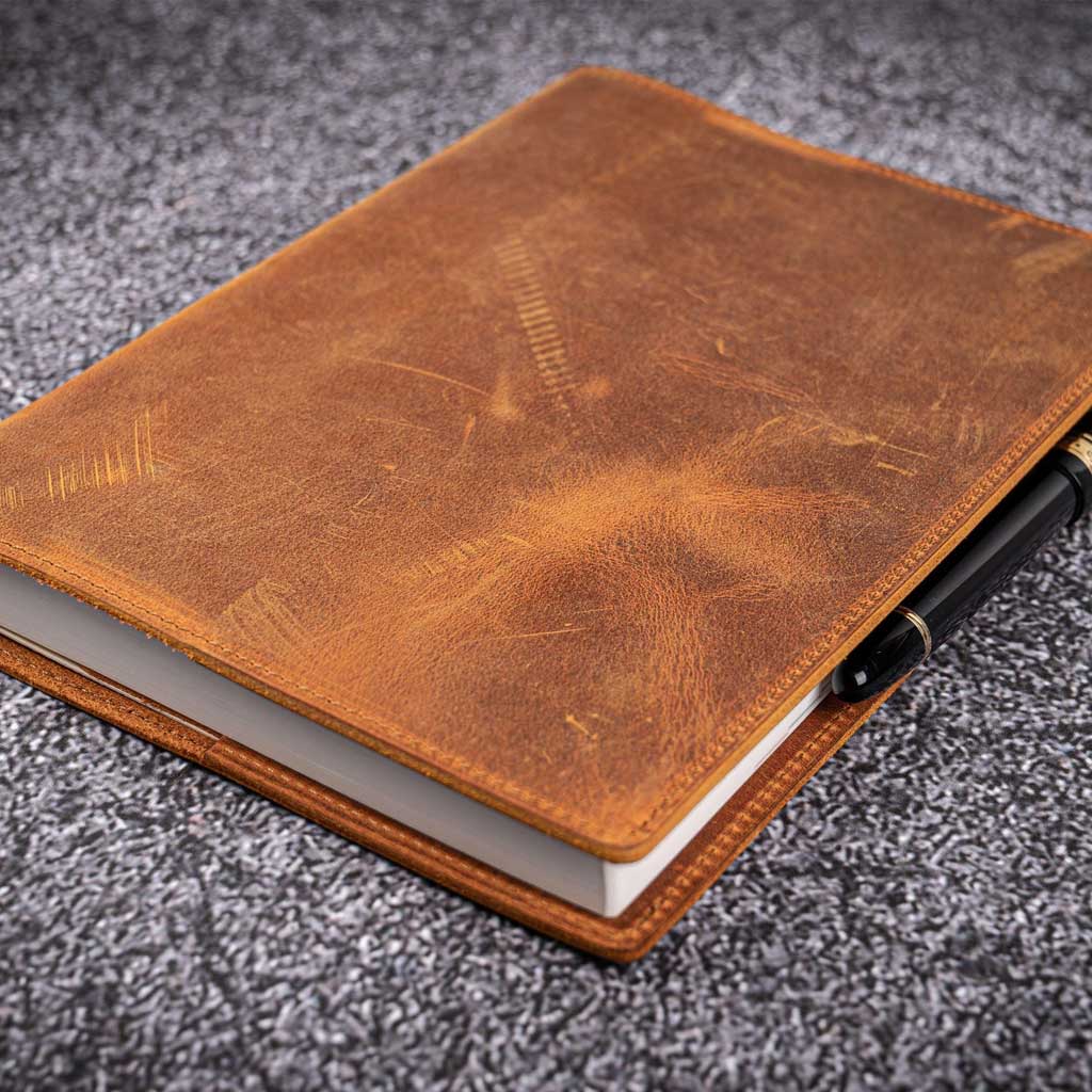 Brown leather notebook on a gray textured surface