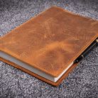 Brown leather notebook on a gray textured surface