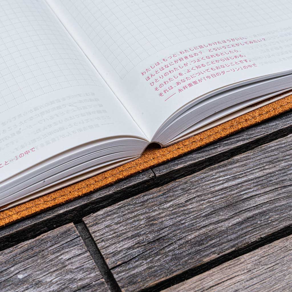 Open book with Japanese text on a wooden surface
