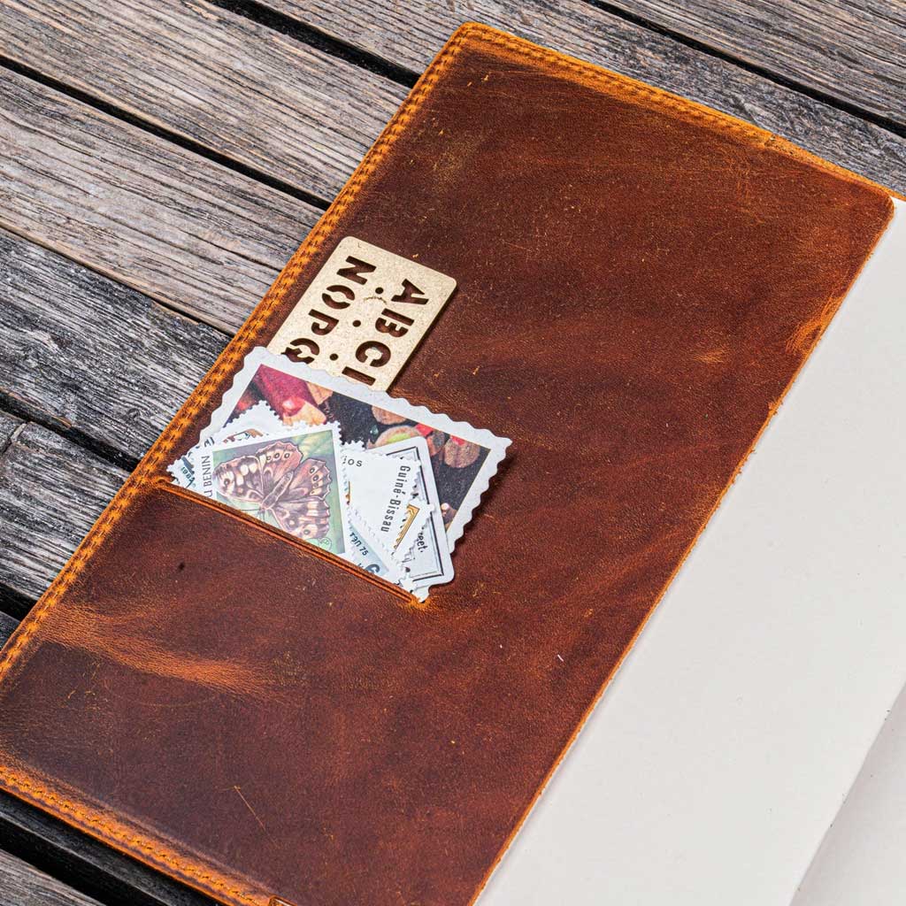 Brown leather notebook cover with cards on a wooden surface