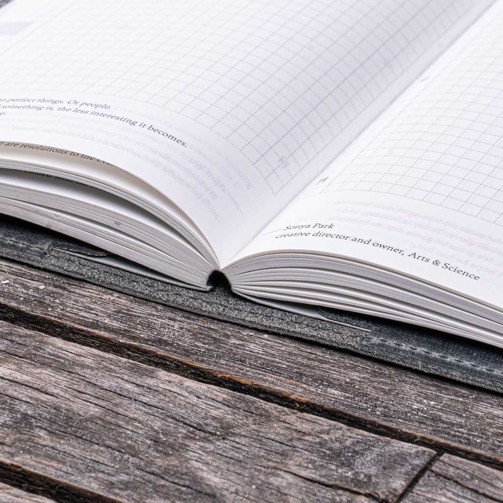 Planner in gray notebook cover on wooden surface