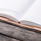 Open book in natural leather notebook cover on a wooden surface