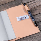 Fountain pen clipped on undyed natural leather notebook cover