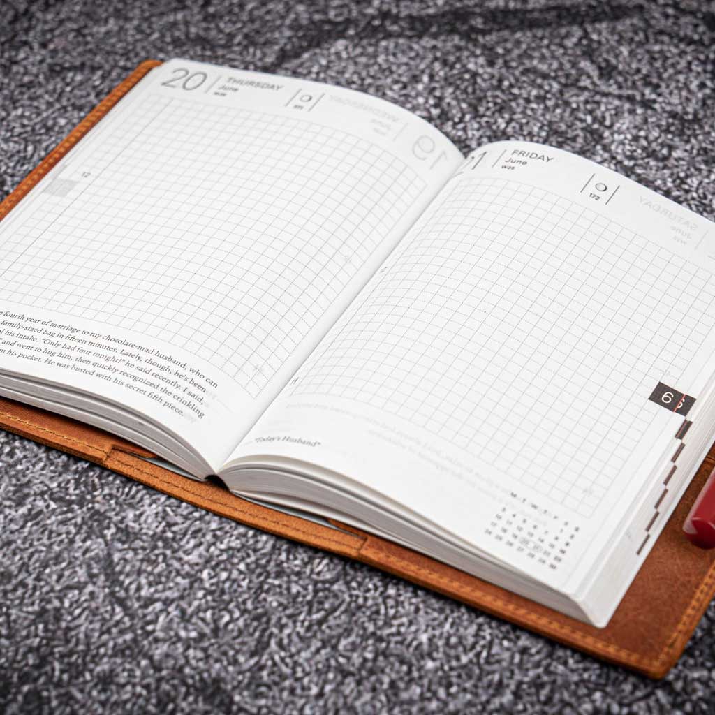 Open planner with grid and plain pages on a textured surface