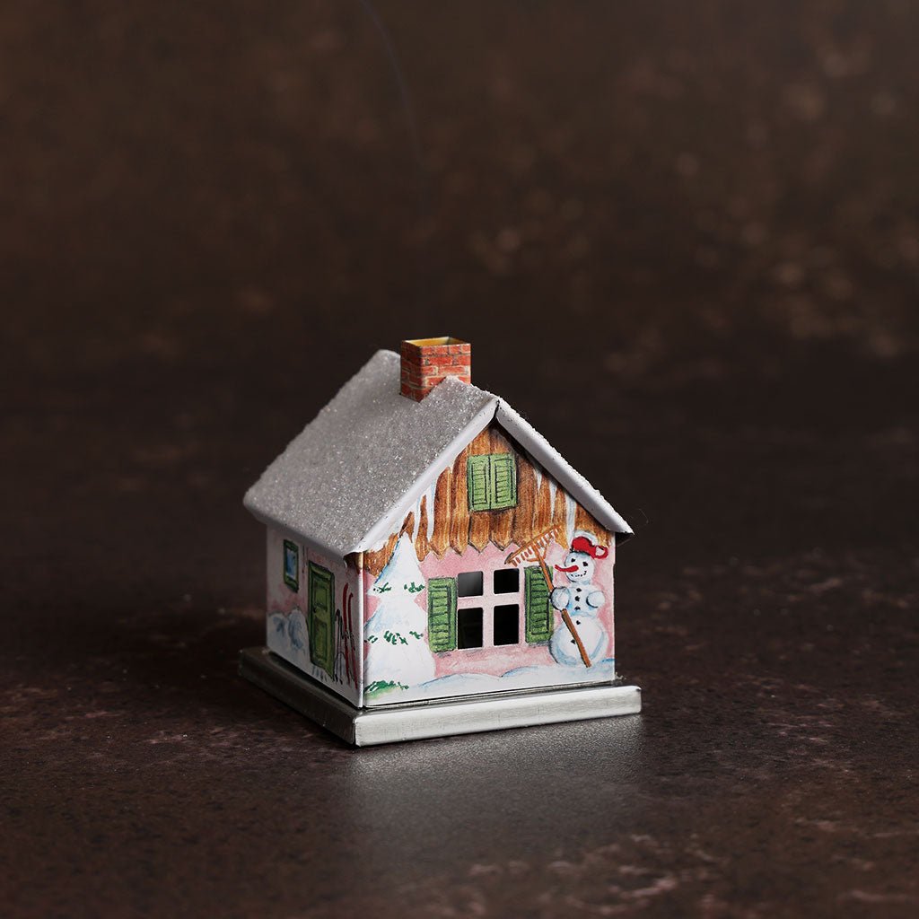 Small metal incense smoker cottage house on dark background