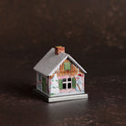 Small metal incense smoker cottage house on dark background