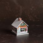 Small metal incense smoker cottage house on dark background