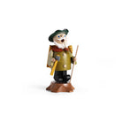 A handcrafted wooden incense burner of a woodcutter standing on a small wooden base. The figure is wearing a green hat, a brown and olive-green coat with a red collar, black pants, and holds a yellow axe and a walking stick.