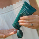Person holding a green tube of Ursa Major Stellar Shave Cream with visible brand name.