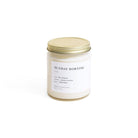 Candle jar labeled 'Sunday Morning' with a gold lid on a white background