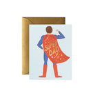 A greeting card with an illustration of a superhero dad wearing a cape with the text 'SUPER DAD' on it. The card is accompanied by a brown envelope.