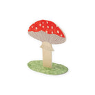 Red mushroom card standing on green grassy base on white background