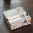 A paper-wrapped parcel decorated with wide washi tape featuring colorful African animals and tied with string.