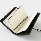 Black card-size notebook with open pages on a white background
