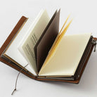 Brown card-size notebook with open pages on a white background
