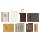 Brown traveler's notebook card-size set with accessories including notebooks, a pouch, and a pen on a white background
