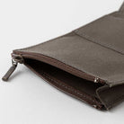 Open brown zippered case against light background