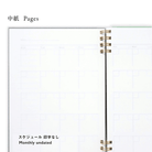 Blank notebook page with grid monthlhy calendar lines and gold binding on a white background