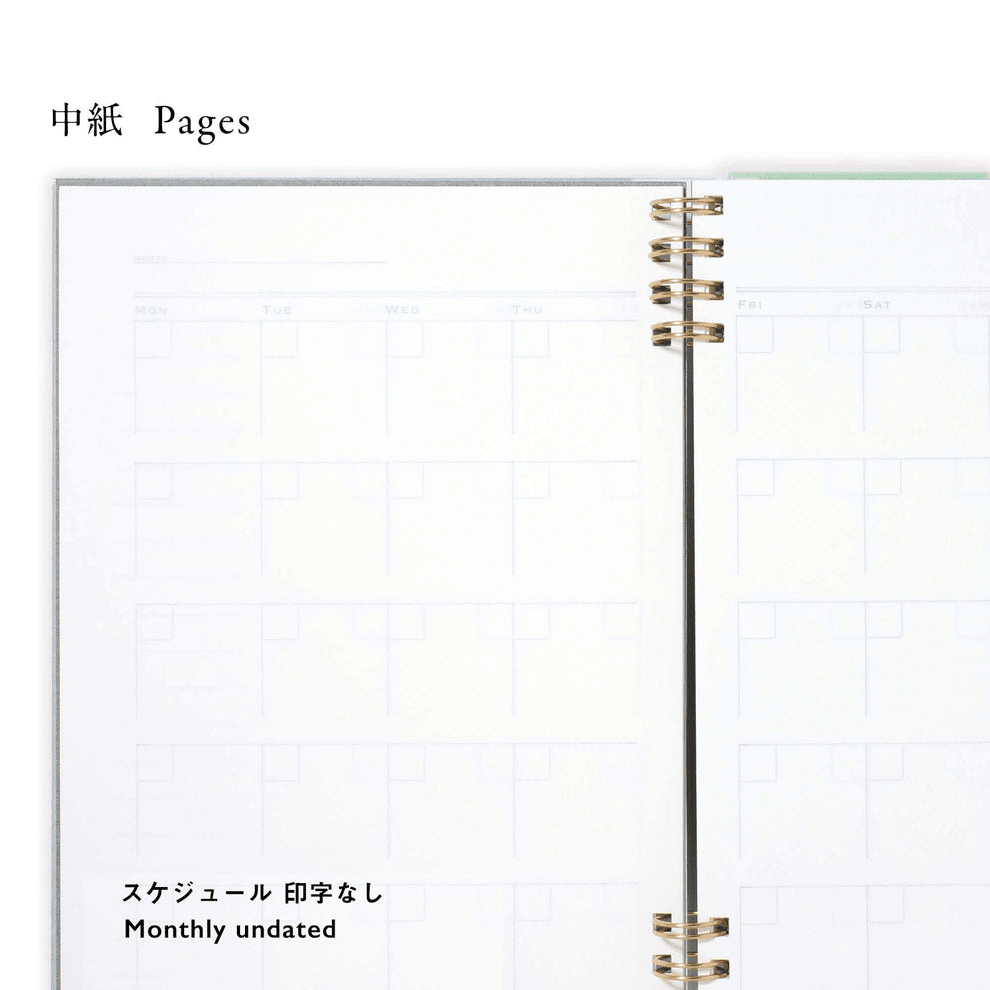 Blank notebook page with grid monthlhy calendar lines and gold binding on a white background