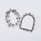 Two decorative black and white stickers with stars and gold accents laying on white surface