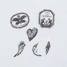 Set of black and white decorative stickers with various designs on a light gray background.