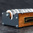 Medium wooden washi tape dispenser with patterned tapes on dark background