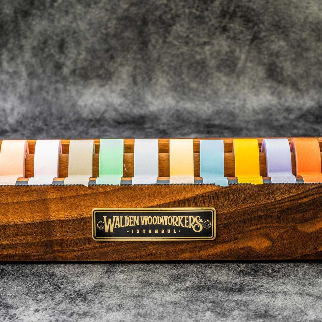 Large wooden washi tape dispenser with colorful tapes on dark background