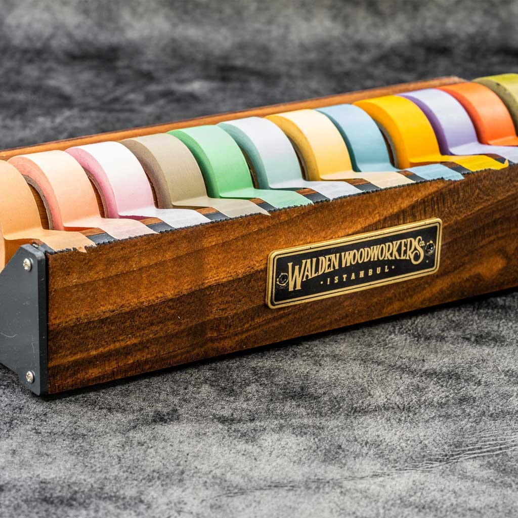 Large wooden washi tape dispenser with colorful tapes on dark background