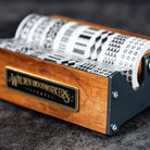 Medium wooden washi tape dispenser with patterned tapes on dark background