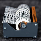 Medium wooden washi tape dispenser with patterned tapes on dark background