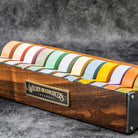 Large wooden washi tape dispenser with colorful tapes on dark background