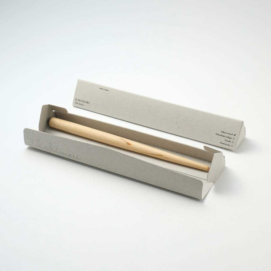 Wooden nib holder in a gray box on a white background